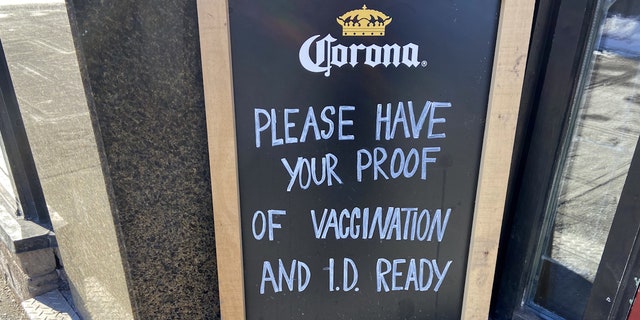 Uma placa do lado de fora de um restaurante no centro de Ottawa solicitando comprovante de vacinação