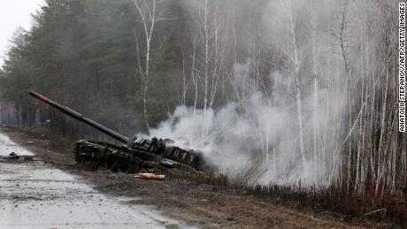 Fumaça sobe de um tanque russo destruído por forças ucranianas na beira de uma estrada na região de Lugansk em 26 de fevereiro de 2022.