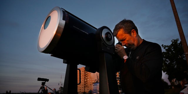Robert Burgess, astrônomo-chefe do sul do Maine, monta um telescópio com filtros solares para observar um eclipse parcial do East Party em Portland na quinta-feira, 10 de junho de 2021.