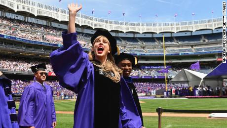 Taylor Swift acena na festa de formatura durante a cerimônia de formatura da Universidade de Nova York em 2022.