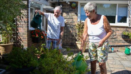 David e Margaret Miller regando suas plantas em sua casa em Edinbridge.