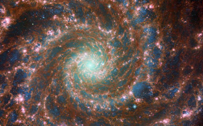 M74 brilha ao máximo nesta imagem composta óptica/infravermelho médio, que incorpora dados do Telescópio Espacial Hubble da NASA/ESA e do Telescópio Espacial James Webb da NASA/ESA/CSA.  & nbsp;  / crédito: Agência Espacial Europeia