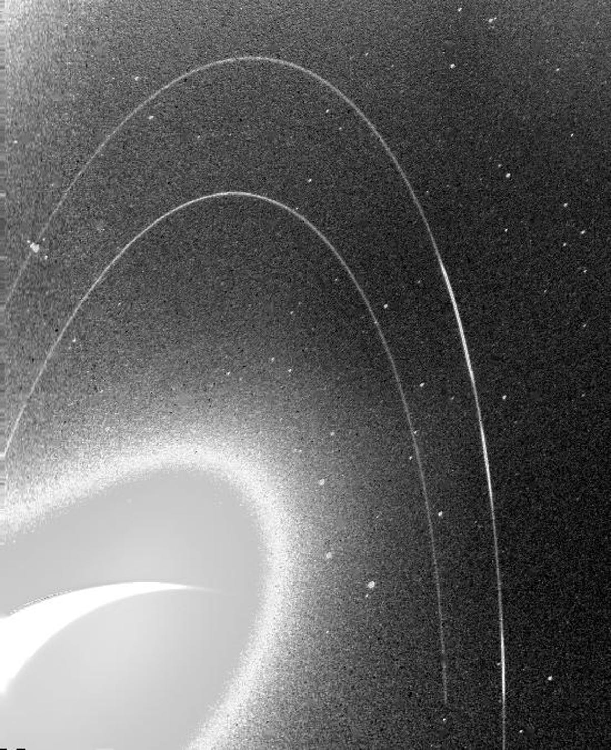 A imagem granulada em preto e branco mostra os anéis fracos de Netuno.