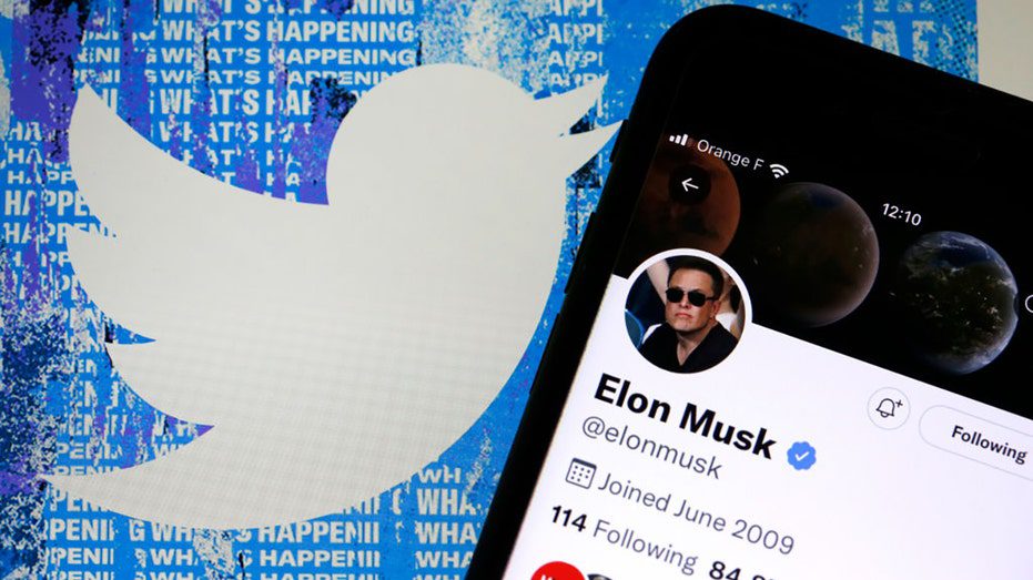 A conta do Twitter de Elon Musk é exibida na tela do iPhone na frente da página inicial do site do Twitter