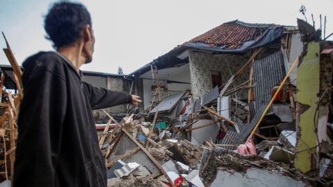 Um homem fica perto de casas danificadas após o terremoto que atingiu Cianjur, província de Java Ocidental, Indonésia, em 21 de novembro de 2022.