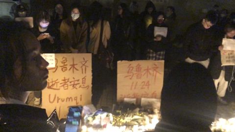 Manifestantes ao lado de cartazes de protesto em Xangai, China, no sábado, 26 de novembro de 2022. 